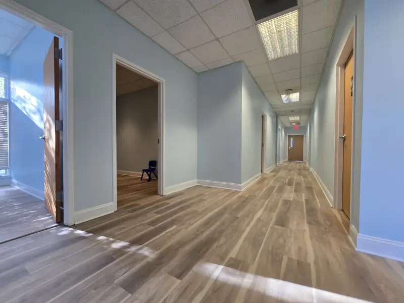 Hallway leading to individual therapy rooms at Blooming Hearts ABA